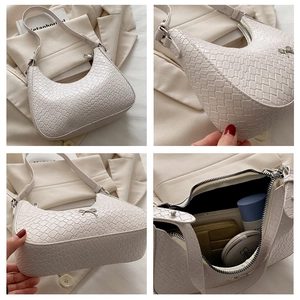 Détail macro du sac crème avec texture tissée et accessoire pendentif nœud en métal