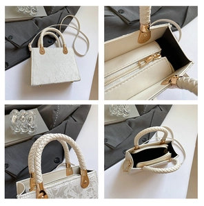 Detail view of white lace textured handbag with woven handles and golden hardware