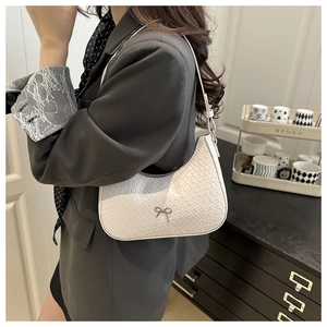 Dettaglio della borsa hobo bianca a stampa coccodrillo con fiocco metallico