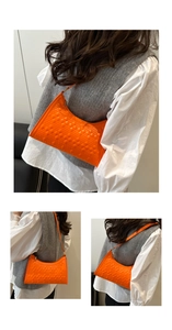 Three-way view of bright orange quilted hobo bag styled as a chic underarm shoulder purse