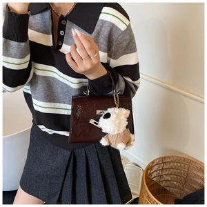 Détail du sac en cuir marron foncé texture croco avec boucle argentée et breloque chien