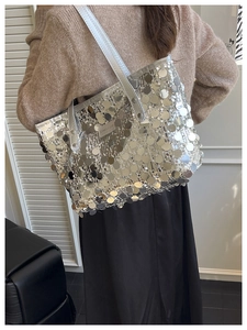 Detailed view of silver sequin tote bag showing glossy texture and shoulder strap