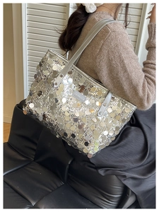 Silver sequin tote bag on model shoulder showing creative cut leather brand label