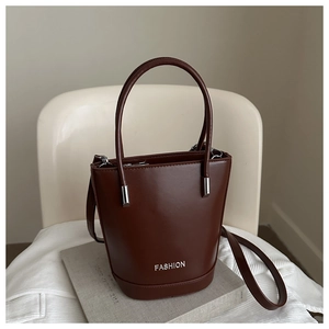 Detailed macro view of the silver FASHION lettering on a brown leather bucket bag