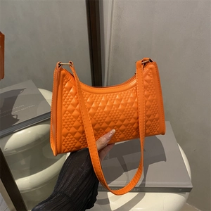 Chic orange crescent underarm bag with geometric quilted pattern and slim shoulder strap