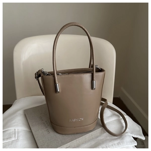 Detail of khaki bucket bag showing silver FASHION lettering and matte leather texture