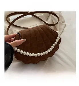 Dettaglio della borsa a tracolla marrone a conchiglia con elegante bordo di perle