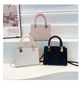 Three-color display of textured square handbags with floral relief and woven handles