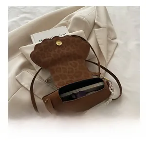 Macro dell'ampio interno con stampa leopardata della borsa a tracolla marrone a conchiglia