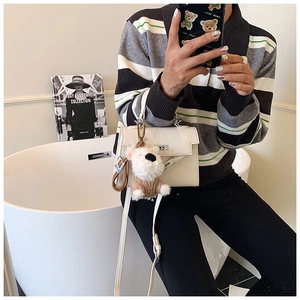 Détail du mini sac crème avec fermoir rotatif en métal et charmant chiot en peluche