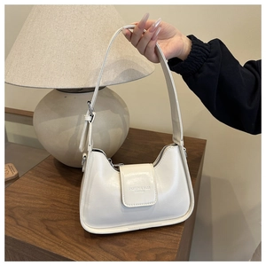 Primer plano del bolso baguette blanco minimalista con su correa ajustable.