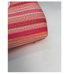 Close-up of multicolored straw woven tote bag showing dense texture and gradient stripes
