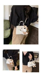 Détails du sac à main en cuir blanc texturé avec fermoir doré et charme chiot