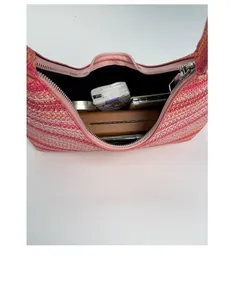 Detail view showing interior capacity of a striped woven tote bag with daily items