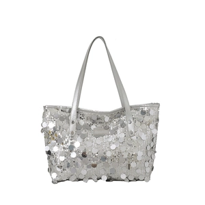 Silver sequin tote bag with large metallic discs and long shoulder straps on white background