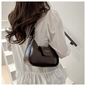 Primer plano de un elegante bolso baguette de cuero marrón en una modelo femenina