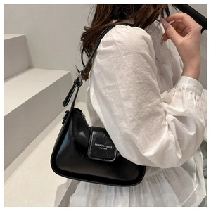Elegante bolso baguette de cuero negro de estilo francés usado por una modelo