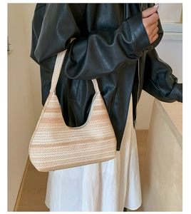 Detail of hand-woven straw tote featuring textured striped pattern and zipper closure