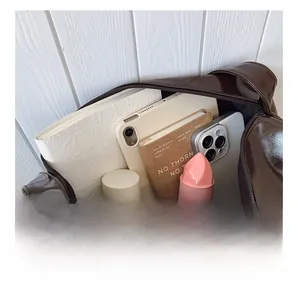 Detail view of large brown shoulder bag interior showing high capacity for tablets