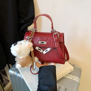 Sac à main Kelly en cuir plissé rouge foncé avec boucles argentées et pendentif chien