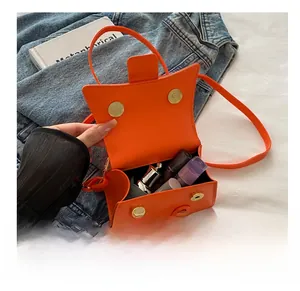 Vue intérieure du petit sac bandoulière orange montrant la capacité pour le maquillage