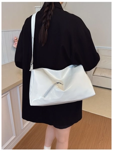 Detail of white glossy tote bag with adjustable wide strap and decorative zipper