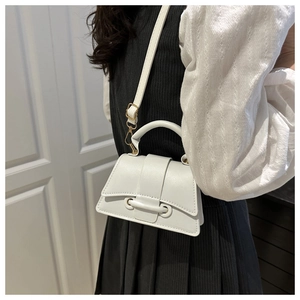 Détail du mini sac à main blanc en cuir avec base incurvée et accessoires en métal doré
