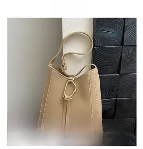 Vue détaillée du sac en PU kaki avec coutures contrastées blanches et boucle dorée