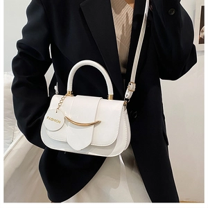 Detail der weißen Ledertasche mit goldener Schnalle und modischem Anhängeranhänger
