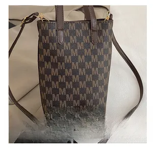 Détail du sac cabas avec motif M monogramme et anses en cuir marron de qualité