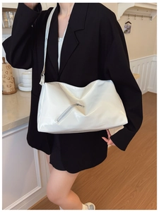 White glossy PU leather tote bag with functional zipper detail on a black blazer outfit