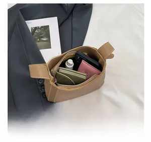 Vue de dessus du sac à bandoulière en cuir marron montrant le rangement interne pour mobile