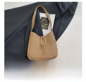 Détail du sac croissant caramel avec surpiqûres blanches et boucle dorée élégante