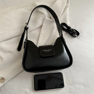Elegante bolso baguette de cuero negro brillante con correa de hombro ajustable