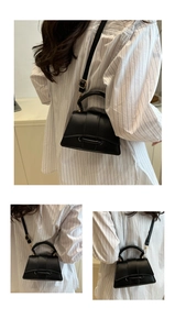 Vue détaillée de la base incurvée distinctive et du cuir lisse d'un mini sac à main