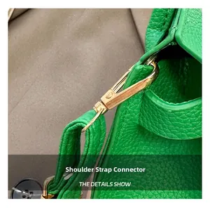Detailed macro of golden metal hook on green lychee grain leather shoulder strap