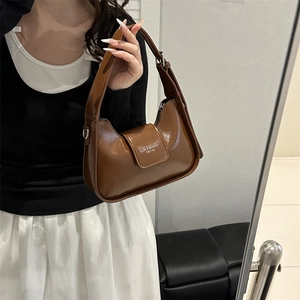 Elegante bolso baguette de cuero marrón estilo francés para mujer, vista espejo.