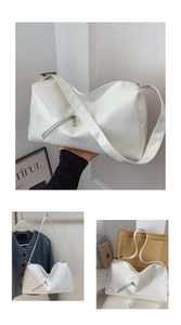 Macro detail of glossy white leather tote with silver zipper and wide shoulder strap