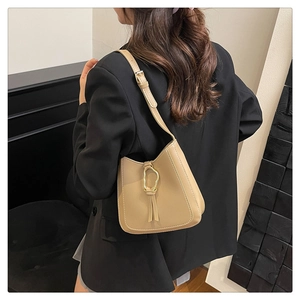 Gros plan d'un sac sous les bras kaki avec surpiqûres et boucle en métal doré chic