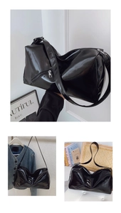 Detail of glossy black large tote bag with silver zipper and wide shoulder strap