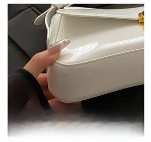 Macro shot of white patent leather surface with precise stitching and gold metal buckle