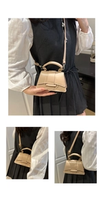 Détail d'un mini sac à main beige avec rabat incurvé et bandoulière amovible élégante