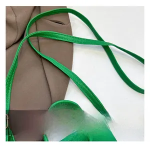 Detail view of vibrant green lychee grain leather mini bag with vintage metal hook and strap