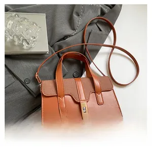 Détail du sac à main en cuir caramel avec rabat tissé et fermoir tournant en métal doré