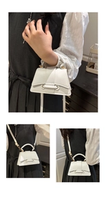 Détail du petit sac blanc minimaliste avec boucle cylindrique et poignée supérieure chic