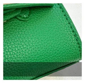 Macro shot of bright green lychee grain leather texture and neat stitching on a mini bag