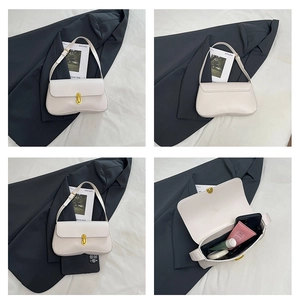 Detail view of cream underarm bag with gold clasp showing front, side and interior capacity