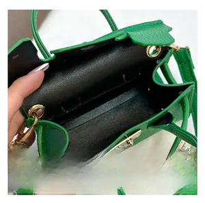 Macro view of green PU mini bag interior showing single compartment and gold lock