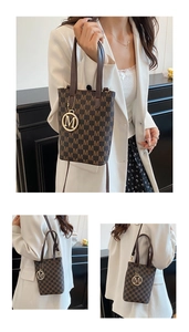 Détail du sac seau marron foncé avec motif M et breloque logo en métal doré