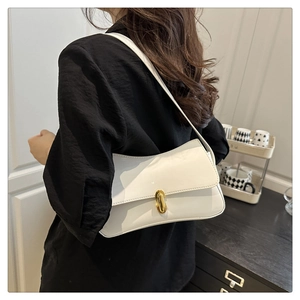 Detail of white glossy leather underarm bag featuring a vintage gold oval twist lock